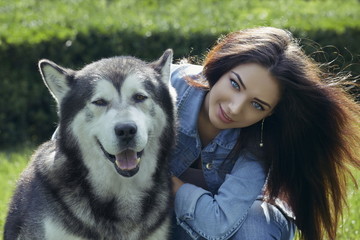 Beautiful smiling woman with Malamute male dog