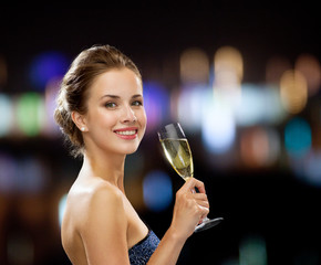 smiling woman holding glass of sparkling wine