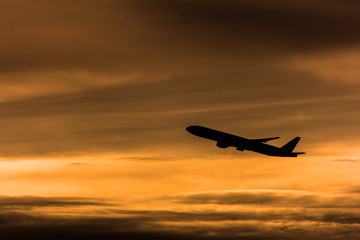Silhouette airplane in the sunset sky
