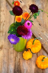 Herbstliche Dekoration mit Dahlien und Kürbissen