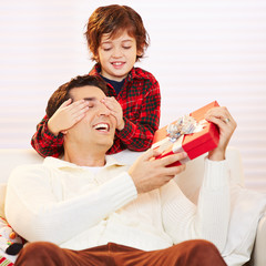 Sohn hält Vater Augen zu an Weihnachten