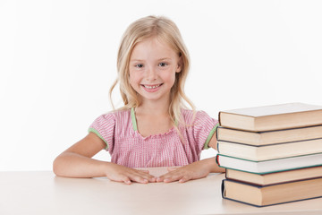 little girl studying literature and smiling.