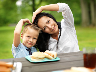 mother and son making heart shape at picnic