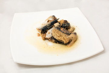 sprats on plate in oil on a white background