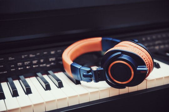 Blue-orange headphones on a digital piano keyboard