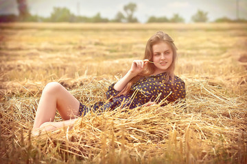 Naklejka na ściany i meble beautiful young brunette girl on the meadow