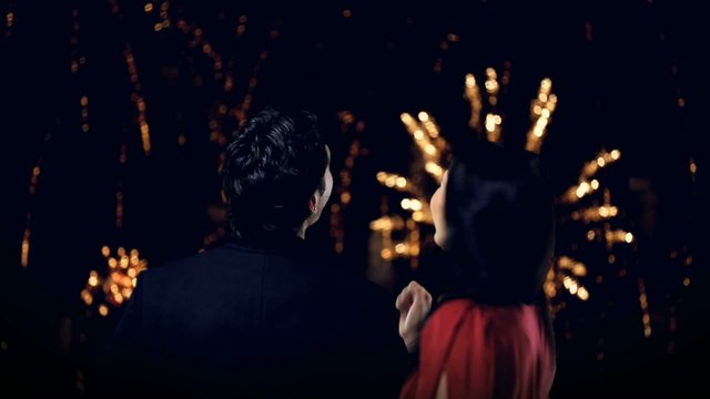 young couple looking at new year's fireworks
