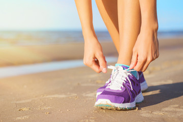 Woman wearing running shoes on the beach