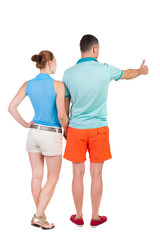 young couple pointing at wal Back view