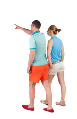 Back view of walking young couple (man and woman) pointing.