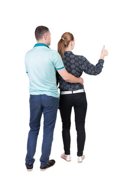 young couple pointing at wal Back view