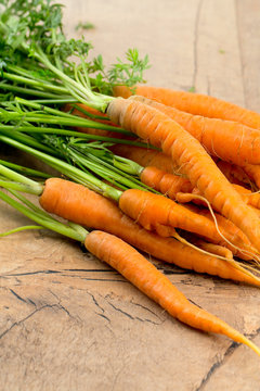 fresh carrots on wooden surface