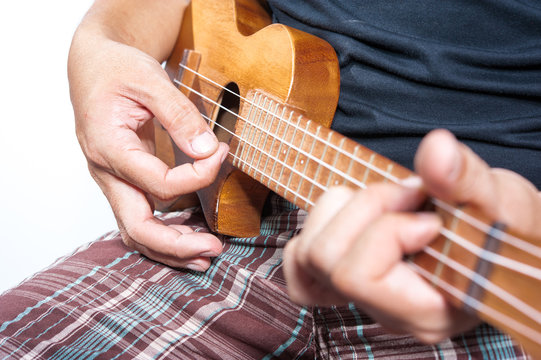 Hand playing ukulele, small string instrument