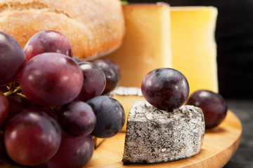 Käseplatte mit roten Weintrauben und Weissbrot