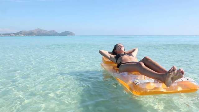 young woman on pool raft in the mediterranean sea, majorca