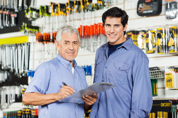 Father And Son Preparing Checklist In Hardware Store