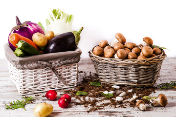 Funghi e ortaggi in cestini su tavolo di legno