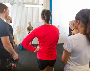 Athletes Listening To Instructor At Gym