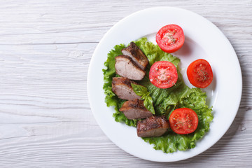 duck meat fillet with tomatoes and lettuce top view