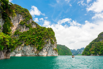 Fototapeta na wymiar Beautiful scene of boat on green clear water with rock mountain