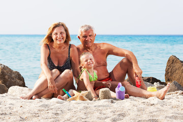 Little girl with grandparents on the beach