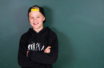 Lächelnder Schüler vor grüner Tafel