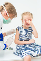 Fototapeta premium Female doctor doing vaccine to little girl.