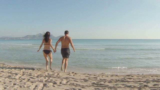 young couple having fun at the beach. majorca, spain.