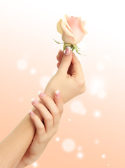Young woman hands with elegance manicure on bright background