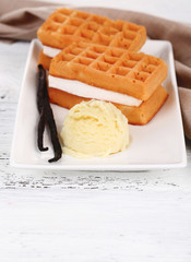 Tasty belgian waffles with ice cream on wooden table