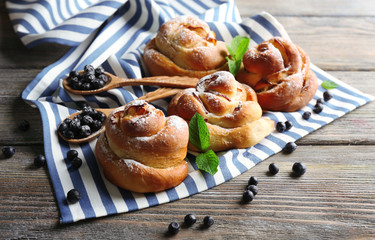 Tasty buns with berries on table close-up