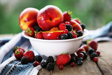 Peaches and berries in bowl on table close-up