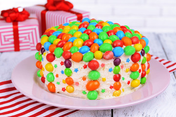 Delicious rainbow cake on plate on table close-up