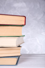 Books on wooden table on light background