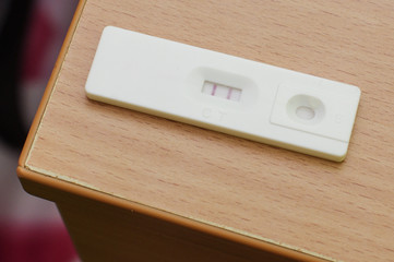 Fototapeta premium Positive pregnancy test on the wooden table