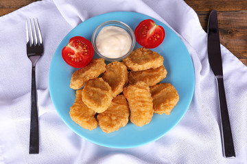 Chicken nuggets with sauce on table close-up