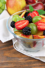 fresh tasty fruit salad on wooden table