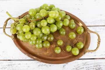 Green grape on tray on wooden background