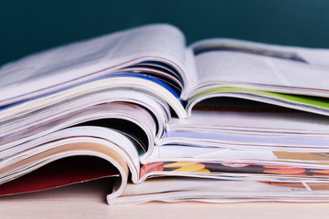Magazines on wooden table on dark background