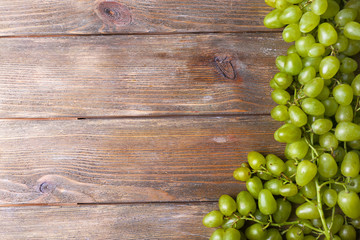 Bunch of ripe grapes on brown wooden background