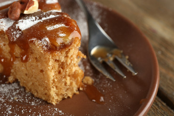 Half eaten delicious cake piece on plate on wooden table