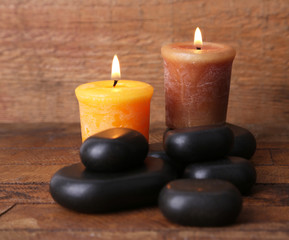 Fototapeta na wymiar Spa stones with candles on wooden background