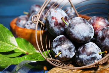 Still life with ripe sweet plums on wooden table