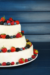 Beautiful wedding cake with berries on  dark wooden background