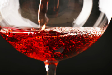 Glass of red wine on dark background closeup