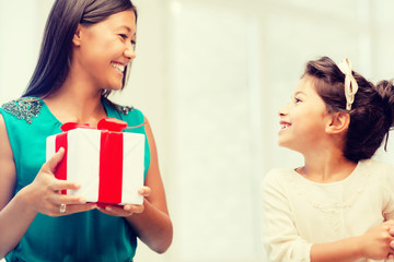happy mother and child girl with gift box