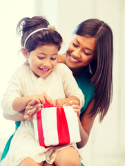 happy mother and child girl with gift box