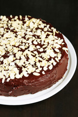 Tasty chocolate cake with almond, on wooden table