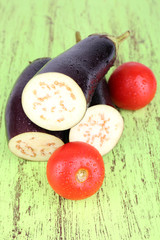 Incised eggplants and tomatoes on wooden background