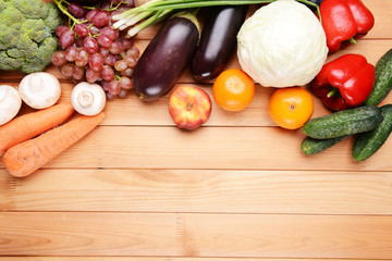 Fresh organic fruits and vegetables on wooden background